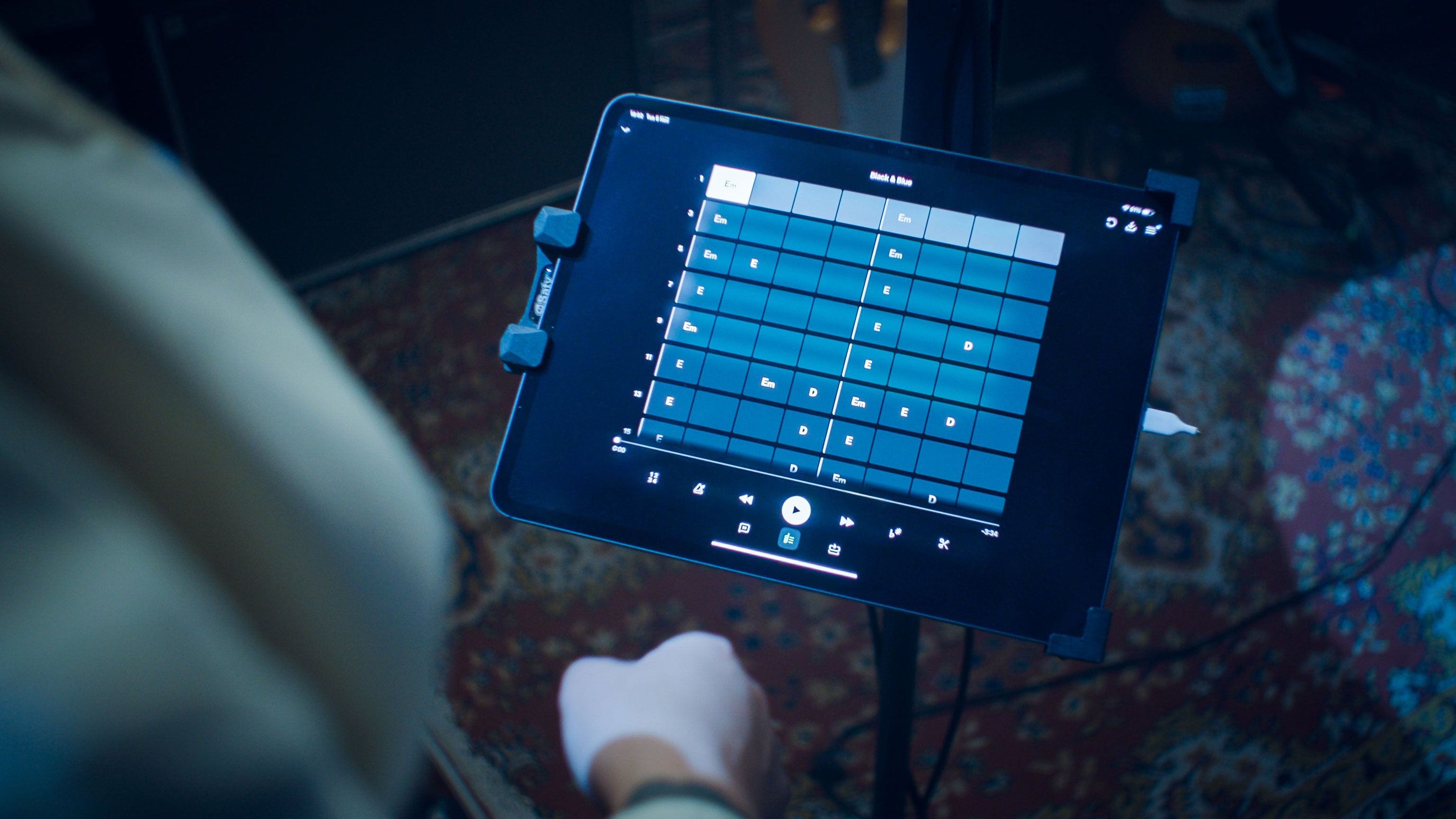An in-studio moment showing a musician using Moises on an iPad, demonstrating real-time control over chords and playback. © 2025 Moises. All rights reserved.